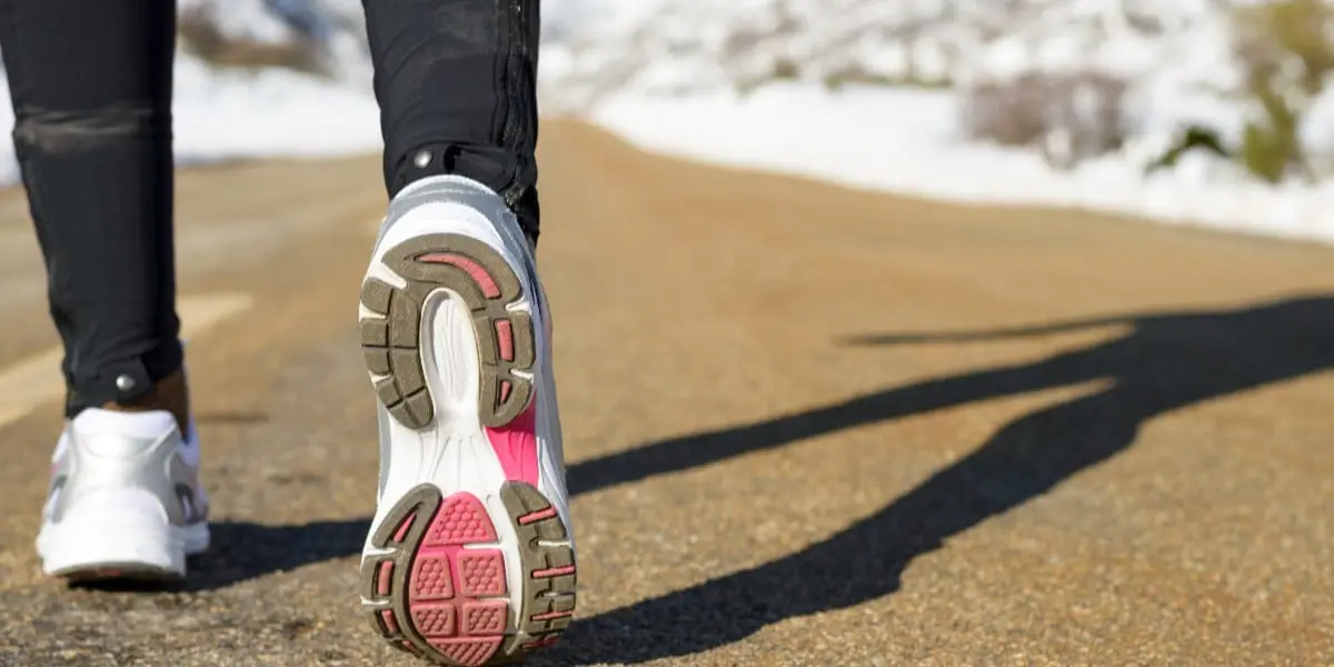 the back of someones running shoe as they pose in the road
